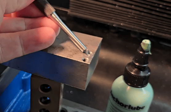 Drive pin punch breaking high spots on a broken tap before drilling with the Omegadrill tap remover