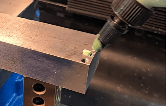Applying cutting oil to Omega Drill during broken tap extraction