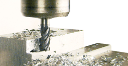 End mill machining a metal block on a milling machine