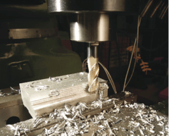 End mill cutting a metal workpiece with machining chips